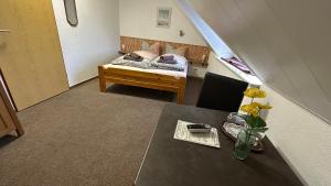 een kamer met een tafel en een bed in een kamer bij Pension Restaurant Pizzeria Lion in Krummhörn