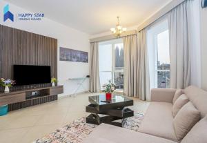 a living room with a couch and a tv at Luxurious 2BR Apartment near Palm Jumeirah in Dubai
