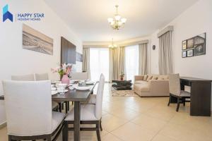 een eetkamer en een woonkamer met een tafel en stoelen bij Luxurious 2BR Apartment near Palm Jumeirah in Dubai