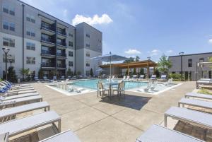 een hotelpatio met een tafel en stoelen en een zwembad bij Luxury 2br Apartment (Buckhead) in Atlanta