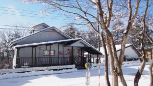 Private hot-spring Villa in Kusatsu في كوساتسو: مبنى صغير فيه ثلج على الارض
