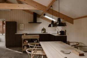 cocina con mesa de madera y sillas en Getaway - Farm House + hottub en Nistelrode