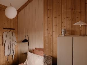 Habitación con paredes revestidas de madera y nevera. en Getaway - Farm House + hottub en Nistelrode