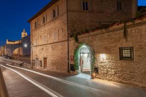 a brick building with an archway on a street at Hotel Sole in Assisi