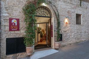 un ingresso a un edificio con una porta con piante di Hotel Sole ad Assisi