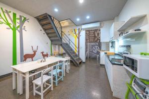 une cuisine avec une table et des chaises ainsi qu'un escalier dans l'établissement Sigang Grandma House, à Xigang
