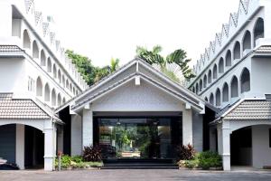 a large white building with a glass door at Pooh Beach Resort & Spa in Jomtien Beach