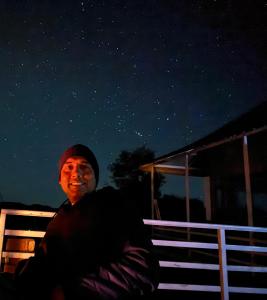 Un uomo seduto su una panchina sotto le stelle di Wanderlust Mukteshwar a Mukteshwar