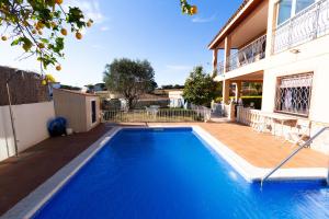 a blue swimming pool in front of a house at Catalunya Casas Heart of Costa Brava and 2,7km to beach in Blanes