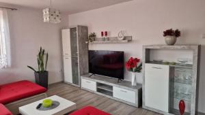 a living room with a television and a red couch at EROPLAN in Ružomberok