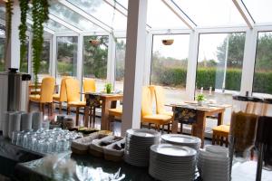 un comedor con mesas, sillas y ventanas en Motel Paradise en Torzym