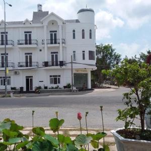 un gran edificio blanco con flores delante en VIEW HOTEL- TRÀM CHIM en Tràm Chim