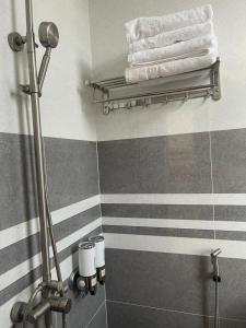 ein Bad mit grauen und weißen gestreiften Wänden und Handtüchern in der Unterkunft VIEW HOTEL- TRÀM CHIM in Tràm Chim