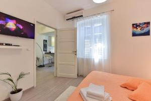 a room with a bed and a tv and a door at Rooms Old Town in Zadar
