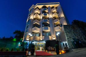 een gebouw waar mensen 's nachts buiten staan bij LİFE POOL SUİTE HOTEL in Trabzon