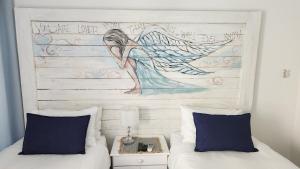 a bedroom with two beds and a painting on the wall at Be Our Guest Self Catering in Nelspruit