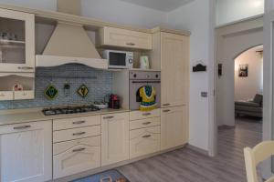 a kitchen with white cabinets and a stove at Casa Sacchet a Longarone in Longarone
