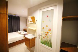 Zimmer mit einem Bett und einem Bad mit einem Fenster in der Unterkunft L Hotel in Bangkok