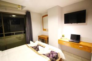 una camera d'albergo con letto e TV di L Hotel a Bangkok
