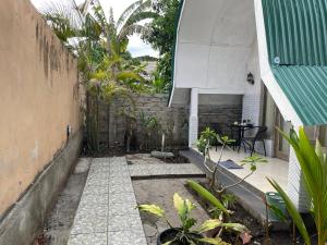 einen Innenhof mit Pflanzen, einem Zaun und einem Tisch in der Unterkunft Rumah Tiga Gili #Lumbung in Gili Air