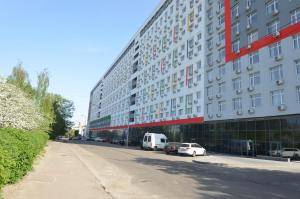 een groot gebouw met auto's geparkeerd voor het bij Rentkiev Smartapart in Kiev