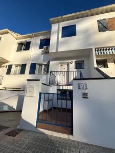 a white building with a gate in front of it at MAGNÍFICO ADOSADO CERCA DEL MAR in Canet de Berenguer