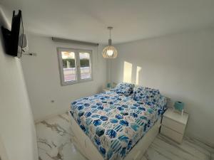 a bedroom with a bed with a blue and white comforter at MAGNÍFICO ADOSADO CERCA DEL MAR in Canet de Berenguer +30 photos