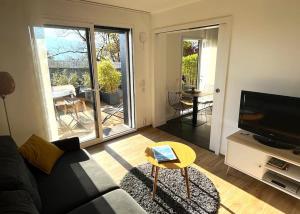 sala de estar con sofá, TV y mesa en 2 room independent appartement 5 mn from Annecy, en Veyrier-du-Lac