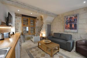 - un salon avec un canapé et une table dans l'établissement Charmante petite maison donnant sur les Arènes, à Arles