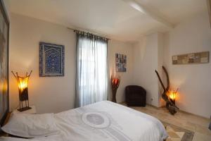 - une chambre avec un lit blanc et une fenêtre dans l'établissement Charmante petite maison donnant sur les Arènes, à Arles