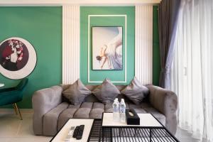 a living room with a couch and a green wall at Otis Soho Saigon Balcony Apartment in Ho Chi Minh City
