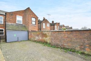 a brick wall with a garage in front of a building at Gresty House - By Sigma Stays in Crewe