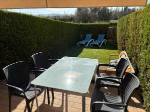 einen Tisch und Stühle auf einer Terrasse mit Sonnenschirm in der Unterkunft Casas Plus Costa Brava in L'Estartit