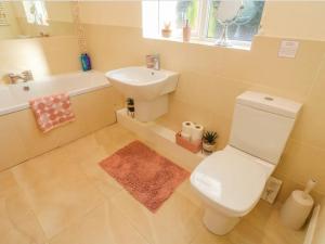 een badkamer met een wit toilet en een wastafel bij Two Acres- Spacious, delightful, pet free bungalow in Levens