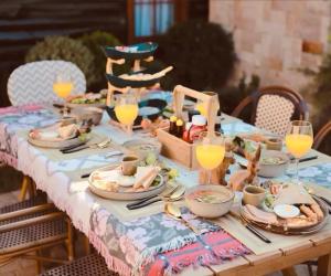 ein Tisch mit Tellern voller Essen und Gläsern mit Orangensaft in der Unterkunft Pine Village CNX in Ban Huai Sai