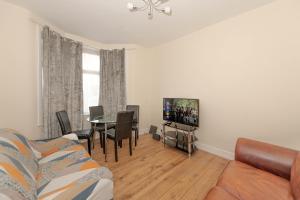a living room with a couch and a table at Cosy 4 bedrooms house near Central London, O2, London city airport and Excel in Plumstead