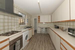 a kitchen with a stove and a dishwasher at Cosy 4 bedrooms house near Central London, O2, London city airport and Excel in Plumstead