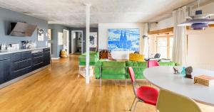 sala de estar con mesa y sillas verdes en FRIZ Holiday Apartments, en Gundelfingen