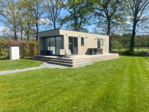 ein kleines Haus inmitten eines Grasfeldes in der Unterkunft Chalet Unique in Oldeberkoop