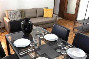 Suite La Montagnola Park 200m Stazione Centrale في بولونيا: غرفة طعام مع طاولة مع الأطباق وكؤوس النبيذ