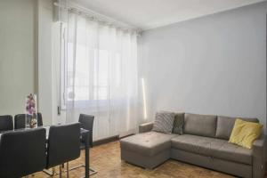 Suite La Montagnola Park 200m Stazione Centrale في بولونيا: غرفة معيشة مع أريكة وطاولة