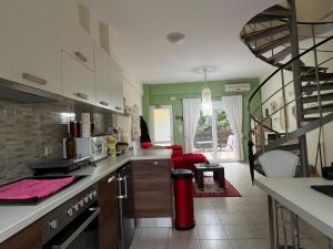 a kitchen with a staircase and a living room at Villa Mandarin Grove Alyanoe in Fodele