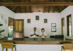 Ein Mann und eine Frau stehen in einem Zimmer in der Unterkunft The Kelong Trikora Resort in Kangkakawal