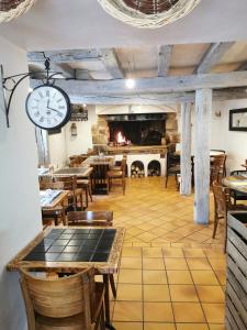 restauracja ze stołami i zegarem na ścianie w obiekcie Epicerie Gourmande w mieście Villandry