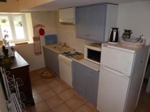a kitchen with blue cabinets and a white refrigerator at GITE LE PARC in Villamblard