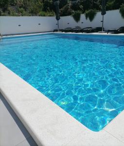 a swimming pool with blue water in a building at Villa Barbara & Zoran with heated swimming pool in Seget Vranjica