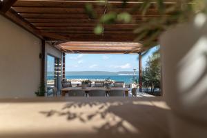a table with chairs and a view of the ocean at Courtside Luxury Villa Dalmatia in Dobropoljana