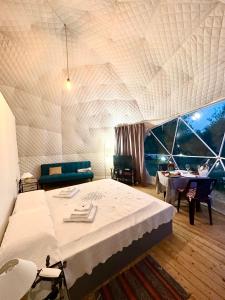 sypialnia z łóżkiem i stołem oraz pokój w obiekcie Glamping Domes San Martino w mieście Itri
