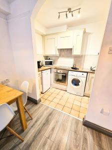 a kitchen with white cabinets and a table and a stove at Dublin Exchange Suites in Dublin