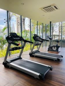 a row of treadmills in a gym with windows at Dorsett Suites City Center KL in Kuala Lumpur